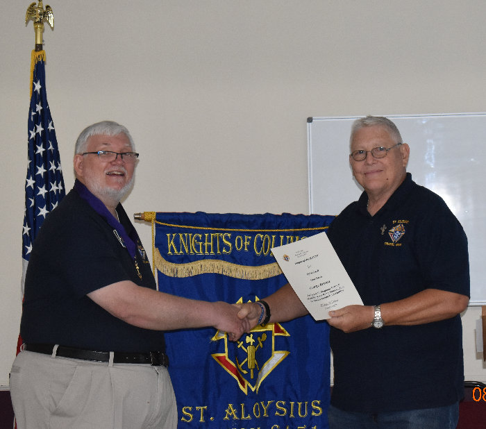 Grand Knight Eddie Williams (left) presensts Grand Knight Elect George Brown with the Knight of the Month Award